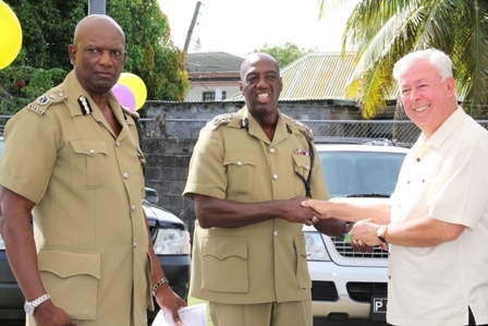 Commissioner of the Royal St. Christopher and Nevis Police Force Celvin G. Walwyn (middle) receives keys to the vehicles from Four Seasons Resort Home Owner Mr. Higginbotham (right). Assistant Commissioner of Police in charge of the Nevis Police Division Mr. Robert Liburd (left) looks on